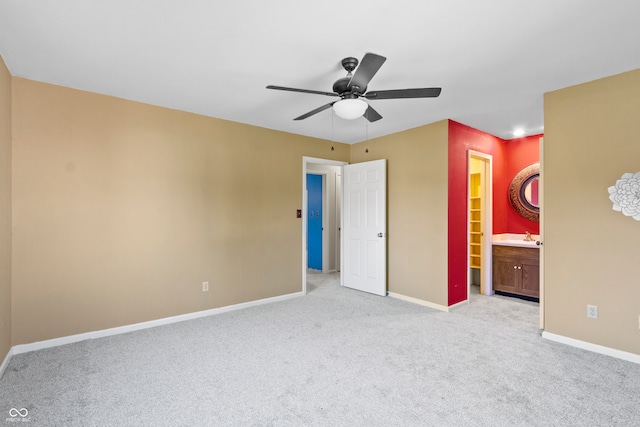 unfurnished bedroom featuring ceiling fan, light colored carpet, and ensuite bathroom