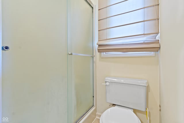 bathroom with toilet and an enclosed shower