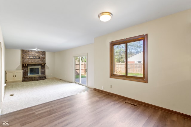 unfurnished living room featuring light wood-type flooring and a fireplace