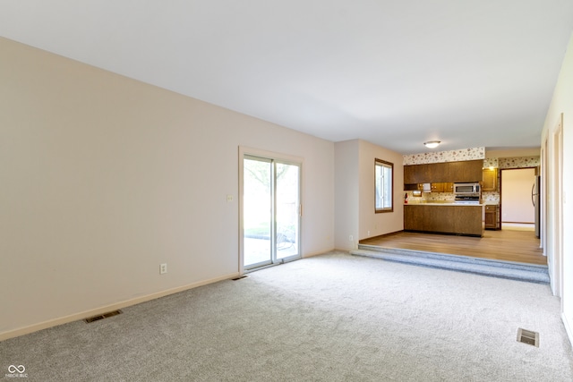 unfurnished living room with light carpet