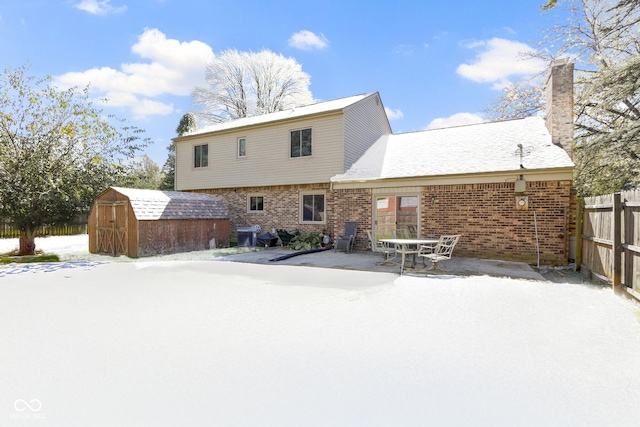 snow covered house with a storage unit