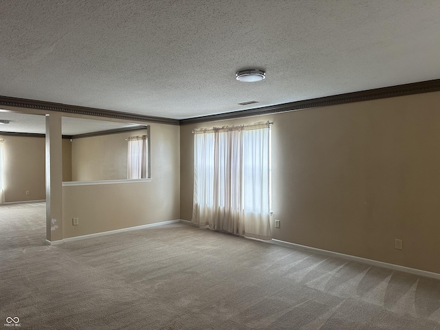 unfurnished room with crown molding, carpet, and a textured ceiling