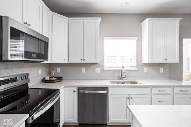 kitchen with appliances with stainless steel finishes, sink, and white cabinets