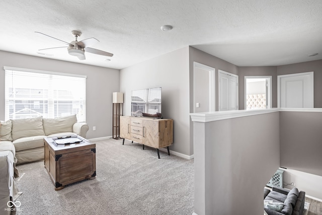 carpeted living room featuring a textured ceiling and ceiling fan