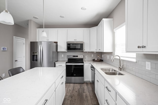 kitchen with decorative light fixtures, appliances with stainless steel finishes, sink, and white cabinetry