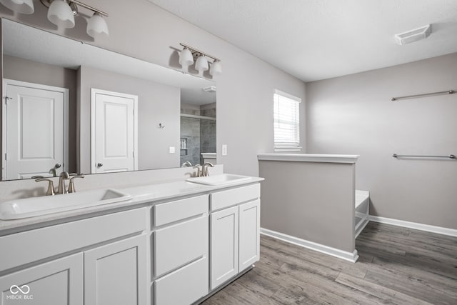 bathroom with wood-type flooring, vanity, independent shower and bath, and a textured ceiling