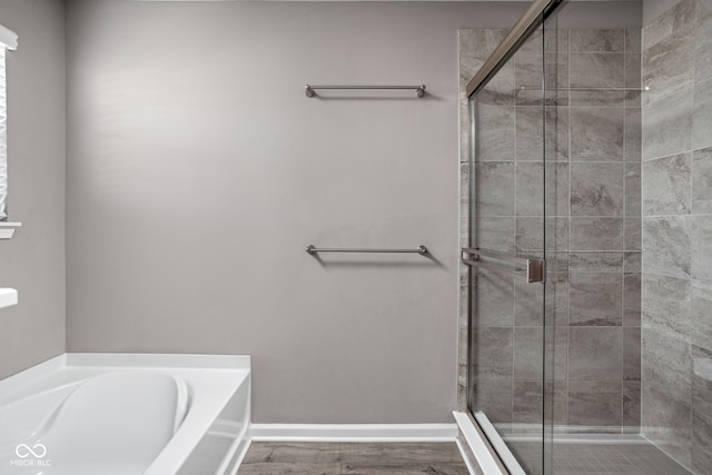 bathroom with independent shower and bath and wood-type flooring