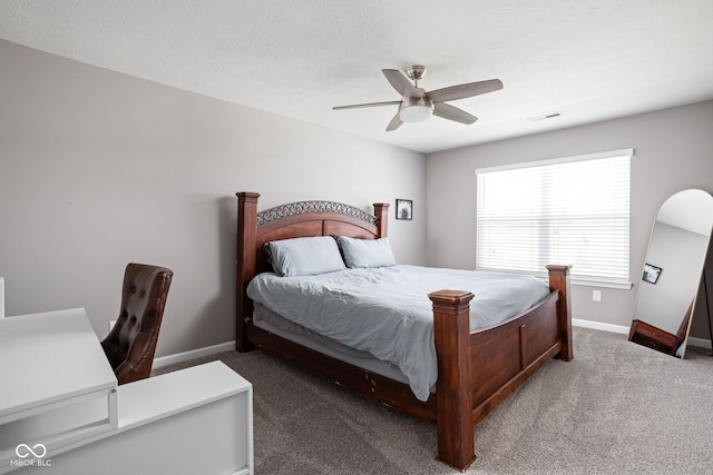 bedroom featuring dark carpet, a textured ceiling, and ceiling fan