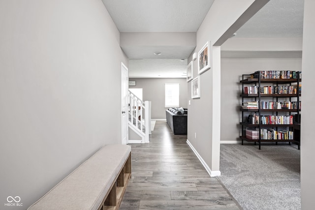 corridor featuring wood-type flooring and a textured ceiling