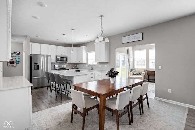 dining area featuring dark wood-type flooring, sink, and a wealth of natural light