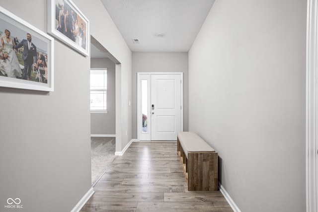 doorway featuring wood-type flooring and a textured ceiling