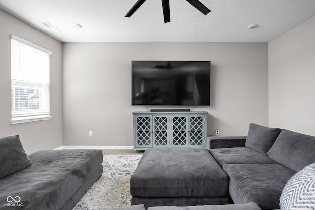 living room featuring hardwood / wood-style flooring, a textured ceiling, and ceiling fan