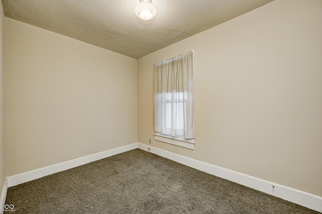 empty room with carpet floors and a textured ceiling