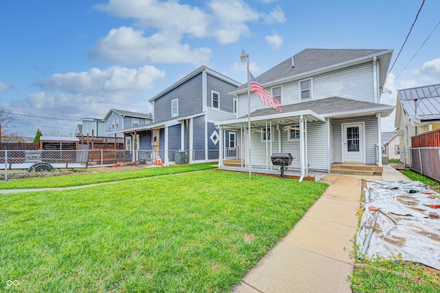 rear view of property featuring cooling unit and a lawn