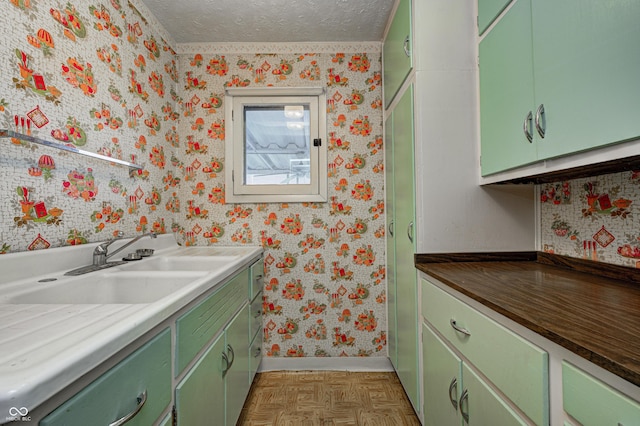 bathroom featuring parquet flooring, vanity, and a textured ceiling