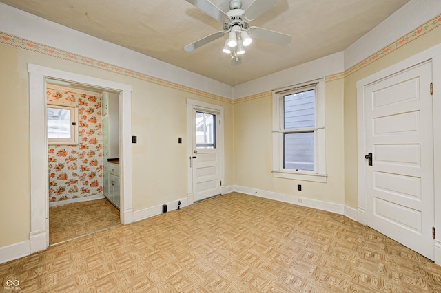 empty room with ceiling fan and light parquet flooring