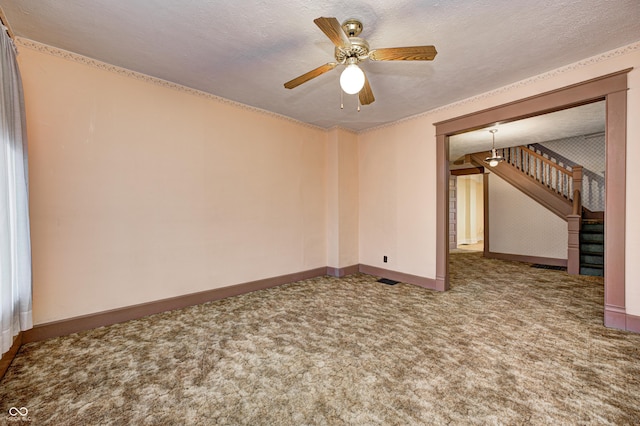 carpeted spare room with ceiling fan and a textured ceiling