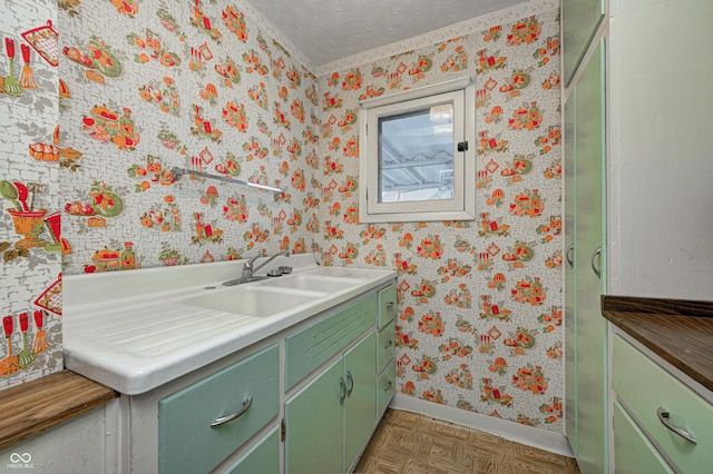 bathroom featuring parquet flooring, vanity, and a textured ceiling