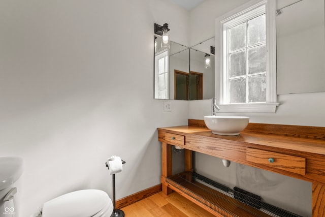 bathroom with wood-type flooring, vanity, plenty of natural light, and toilet