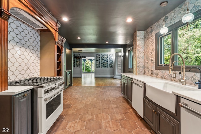 kitchen featuring stainless steel appliances, backsplash, decorative light fixtures, and dark brown cabinets