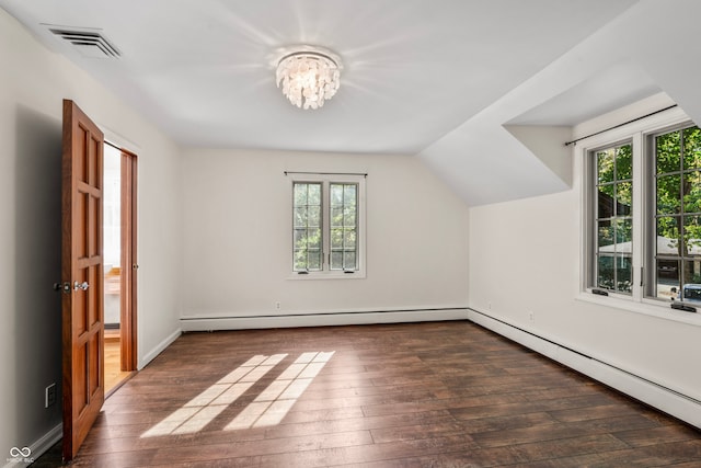 additional living space featuring lofted ceiling, baseboard heating, dark wood-type flooring, and a healthy amount of sunlight