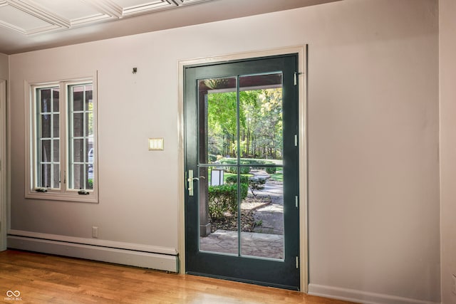 doorway with light wood-type flooring and baseboard heating