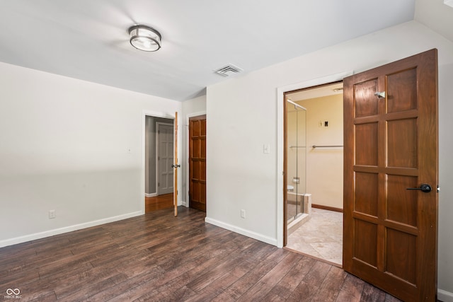 unfurnished bedroom with a closet, dark hardwood / wood-style floors, and a walk in closet