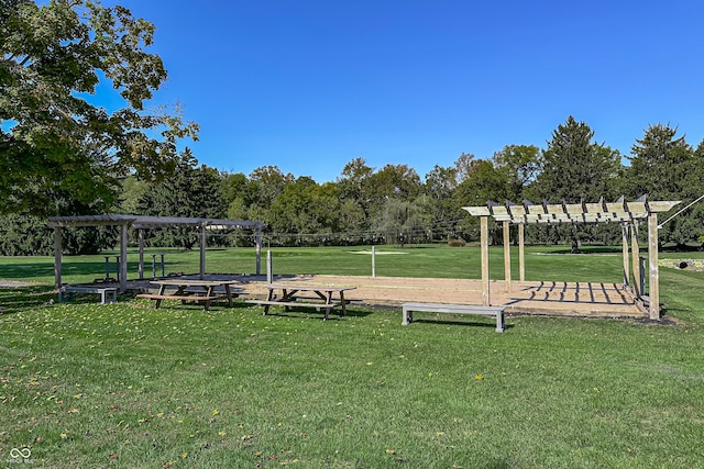 view of property's community with a pergola and a lawn