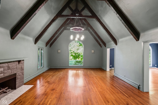 unfurnished living room with a healthy amount of sunlight, beamed ceiling, hardwood / wood-style flooring, and a baseboard radiator