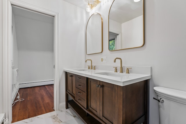 bathroom featuring hardwood / wood-style floors, a baseboard heating unit, vanity, and toilet