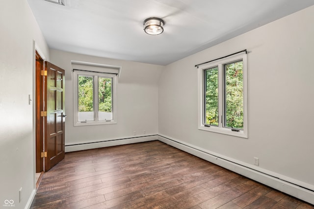 empty room featuring dark hardwood / wood-style floors and baseboard heating