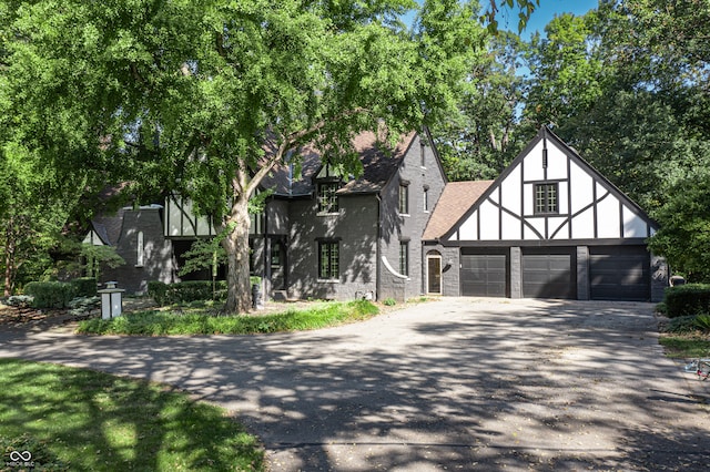 english style home featuring a garage