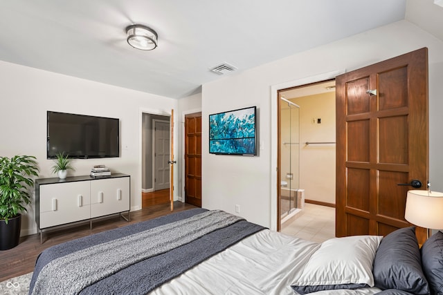 bedroom with lofted ceiling, a closet, connected bathroom, light hardwood / wood-style flooring, and a walk in closet