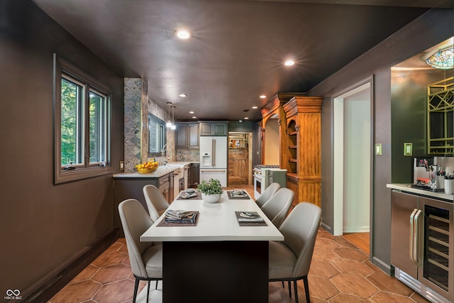 dining area featuring light tile patterned flooring, beverage cooler, and sink