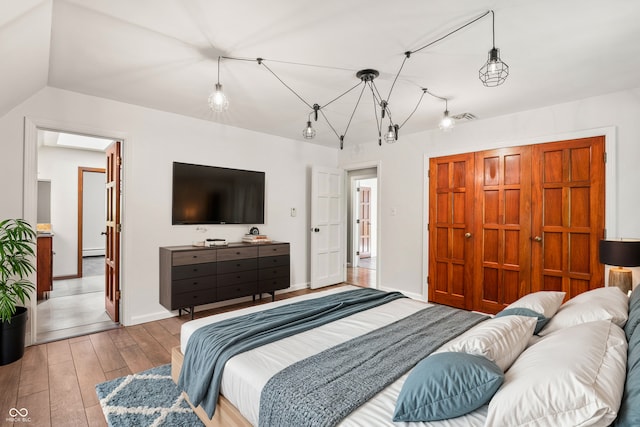 bedroom with vaulted ceiling and light wood-type flooring