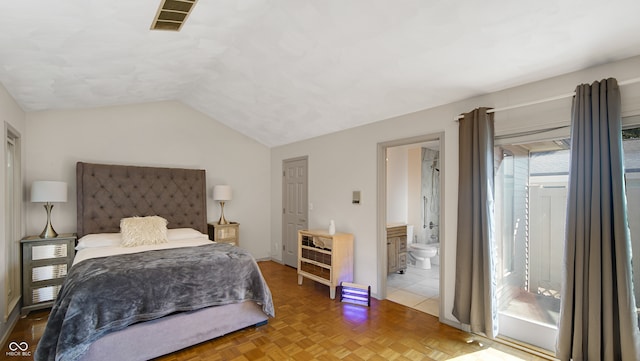 bedroom with vaulted ceiling, ensuite bath, and parquet floors