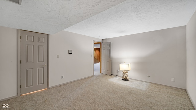 unfurnished room featuring carpet flooring and a textured ceiling