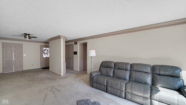 unfurnished living room featuring ornamental molding, decorative columns, ceiling fan, and light colored carpet