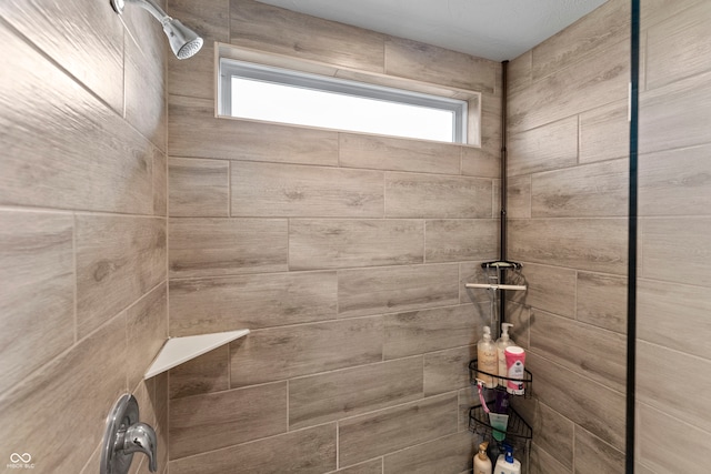 bathroom with a healthy amount of sunlight and tiled shower