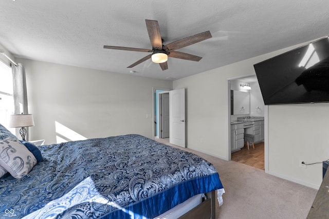 carpeted bedroom with ensuite bath, a textured ceiling, and ceiling fan