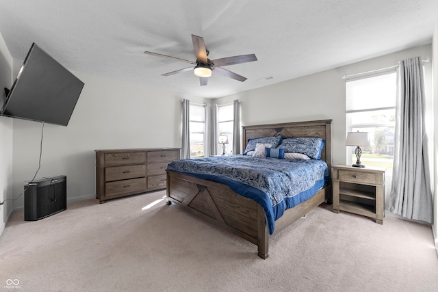 carpeted bedroom with a textured ceiling and ceiling fan