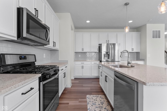 kitchen with white cabinetry, stainless steel appliances, dark hardwood / wood-style floors, and tasteful backsplash