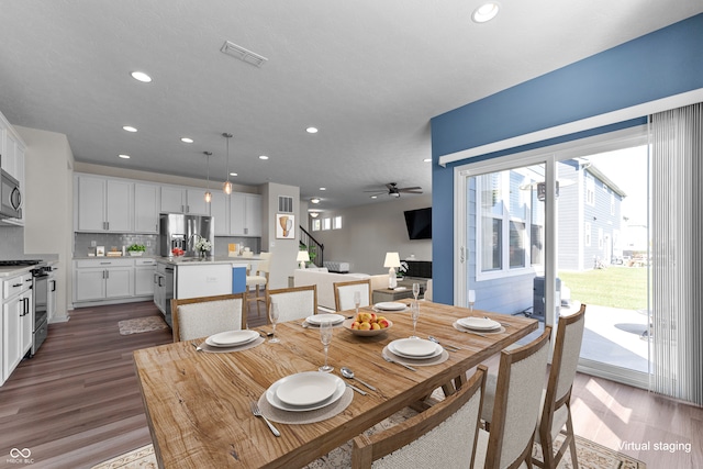 dining space with dark wood-type flooring and ceiling fan