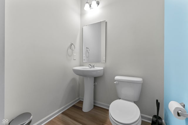 bathroom featuring toilet, wood-type flooring, and sink