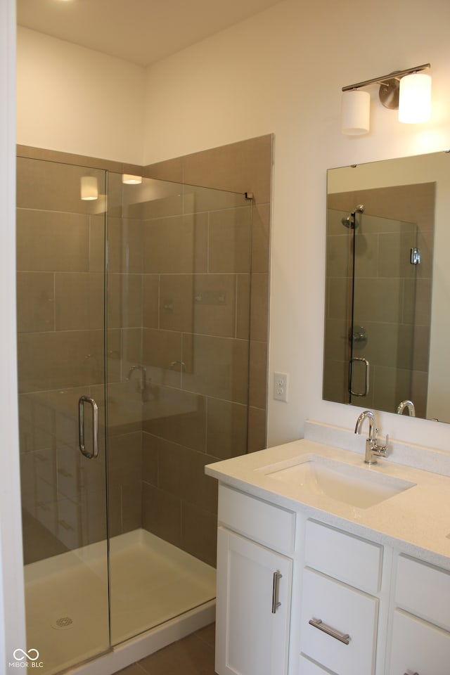 bathroom featuring vanity and a shower with door