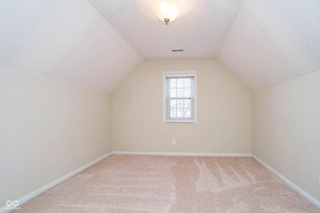 bonus room with carpet flooring and vaulted ceiling