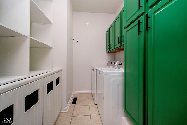 laundry area featuring cabinets, light tile patterned floors, and washing machine and dryer