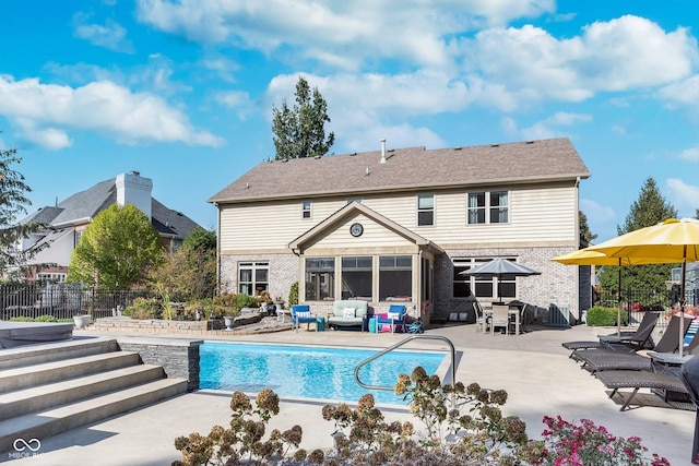 rear view of house with a patio and a fenced in pool