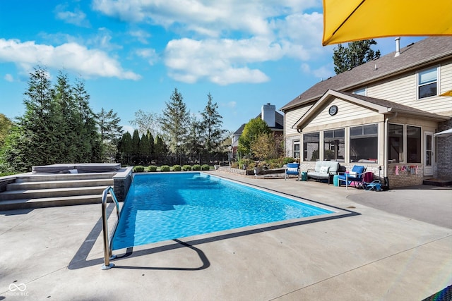 view of pool featuring a sunroom, pool water feature, a patio, and a hot tub