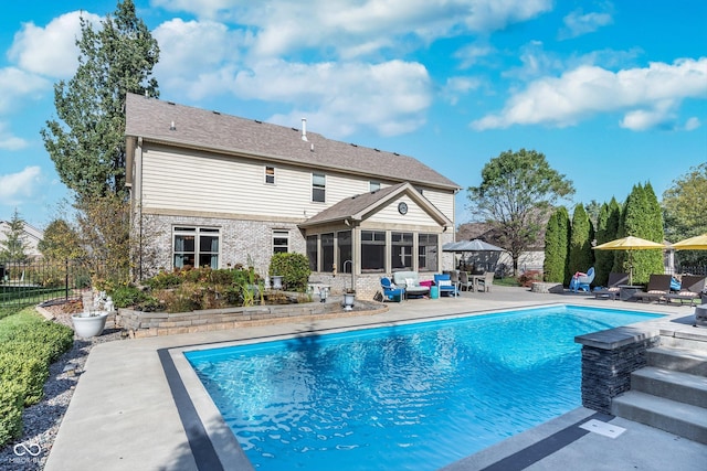 view of swimming pool with a patio and a sunroom